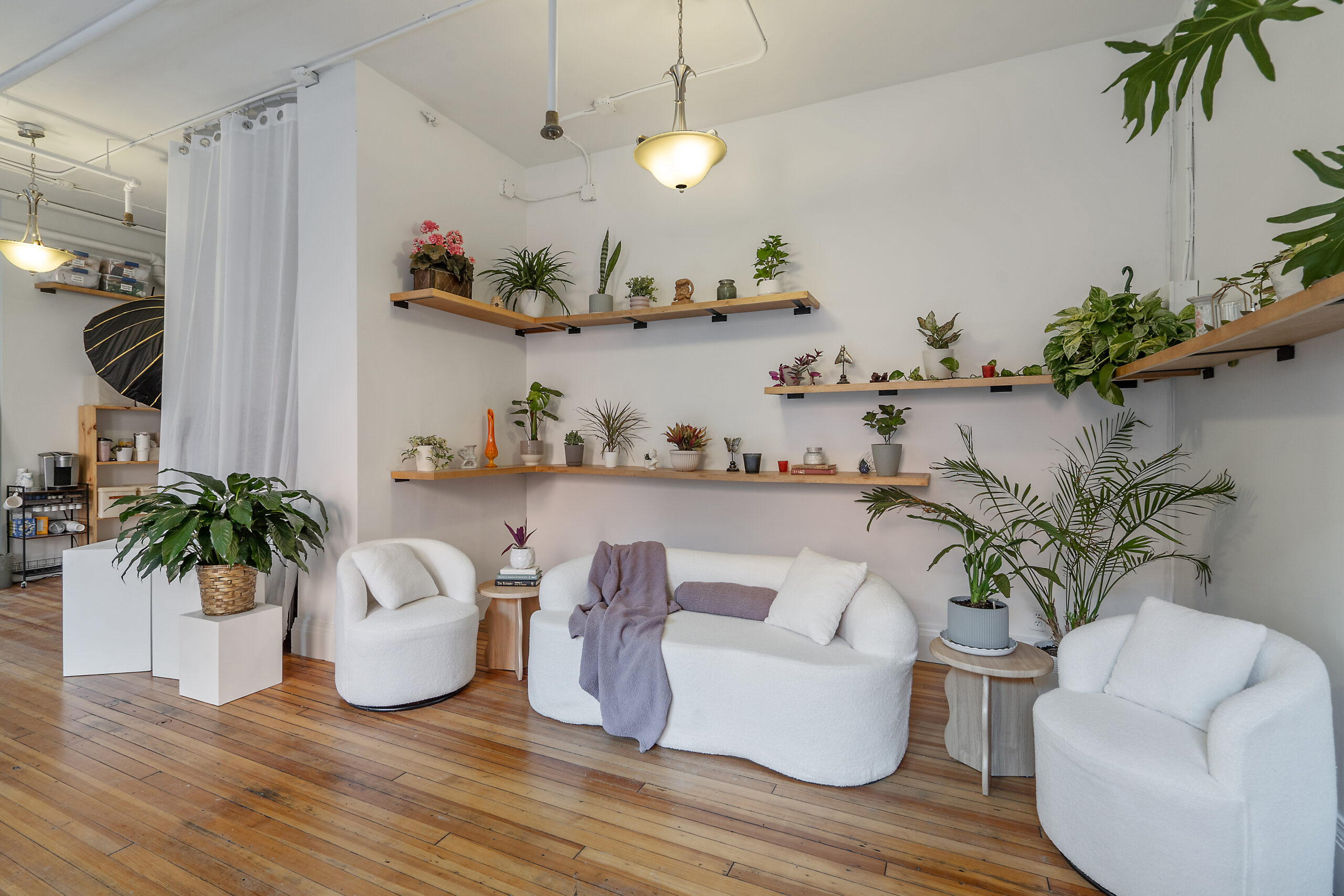 Natural light photo studio in Syracuse with white boucle lounge seating and greenery